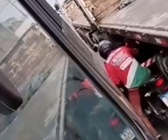 Após tentar passar em corredor inexistente, motociclista fica 'prensado' entre ônibus e caminhão. VEJA VÍDEO