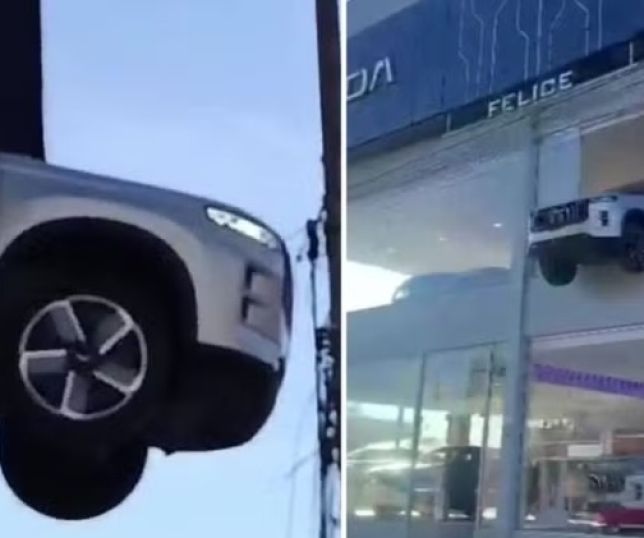 Funcionário erra manobra, quebra vitrine e deixa carro pendurado em concessionária. VEJA VÍDEO