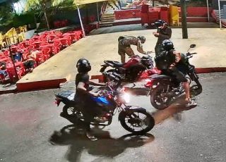 Câmera de segurança filma quatro bandidos assaltando rapazes e roubando motocicleta em frente à capela no bairro Parque Dez de Novembro. VEJA VÍDEOS